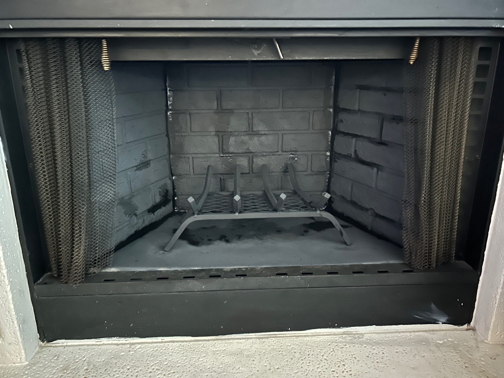 Firebox interior with grate and ash visible during inspection